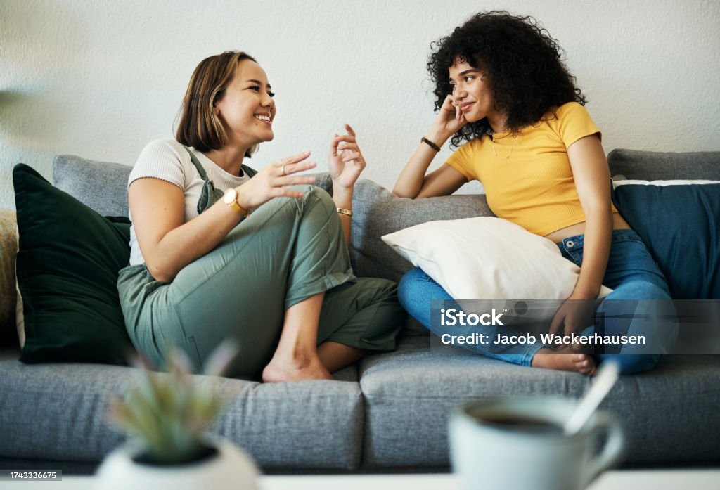 2 Frauen unterhalten sich gemütlich auf einer Couch